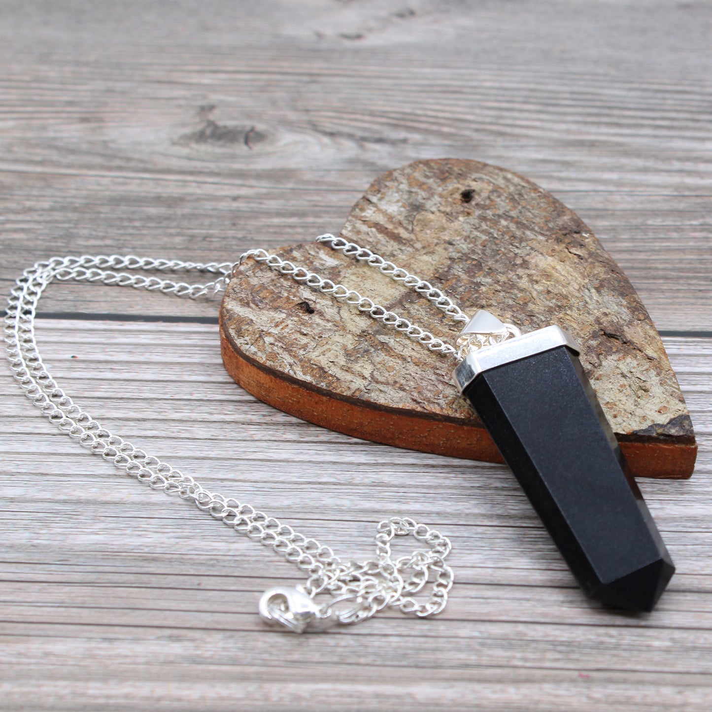 Gemstone Flat Pencil Pendant - Choose your favourite Gemstone, showcasing unique beauty on a silver chain against wood.