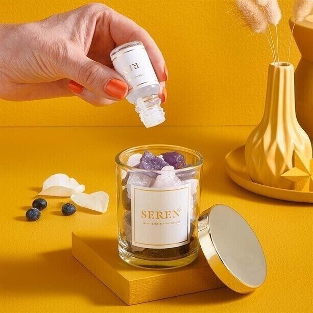 Hand pouring essential oil into the Avon Crystal Diffuser and Oil Gift Set with Rose Quartz and Amethyst stones.