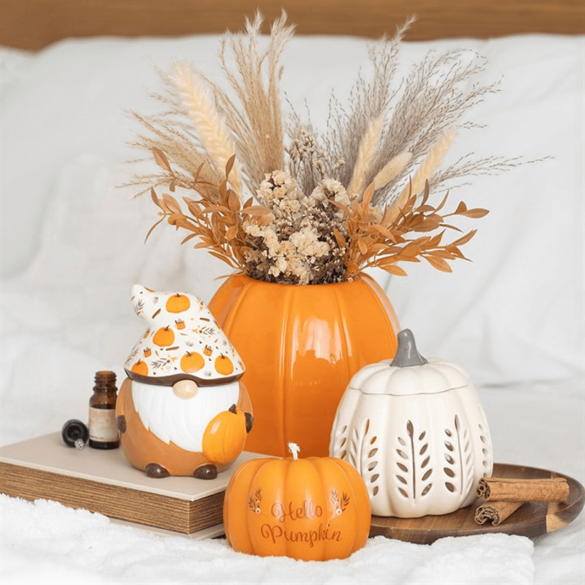 Hello Pumpkin Shaped Candle in cosy autumn display with pumpkins, dried grasses and gnome decor.