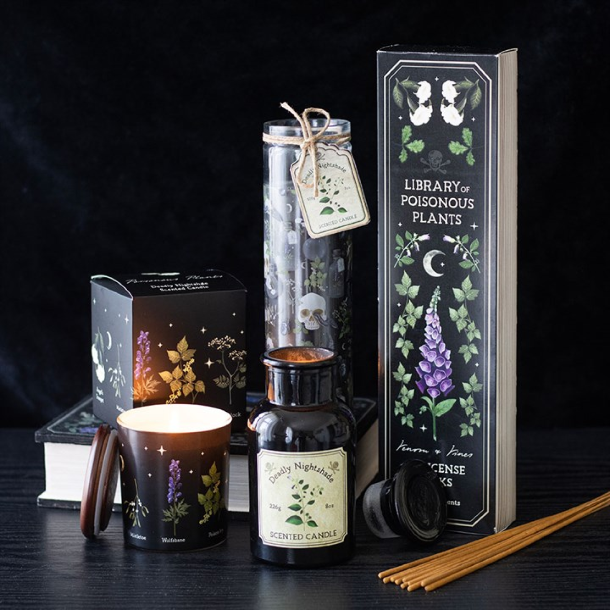 Deadly Nightshade Candle in an apothecary-style glass bottle with label, beside Library of Poisonous Plants box.