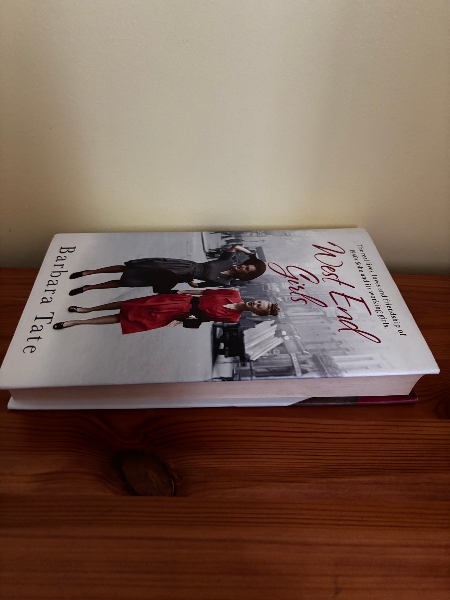 West End Girls By Barbara Tate rests on a wooden surface, showcasing its captivating cover and intriguing story.
