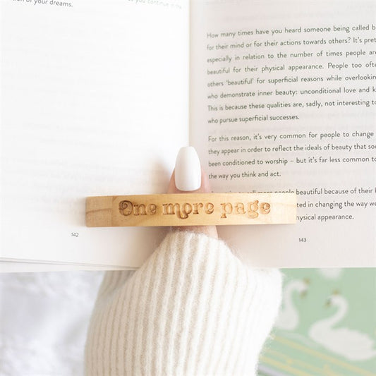 Book Worm Thumb Page Holder, a wooden device slotted over the thumb to hold pages open for easy one-handed reading.