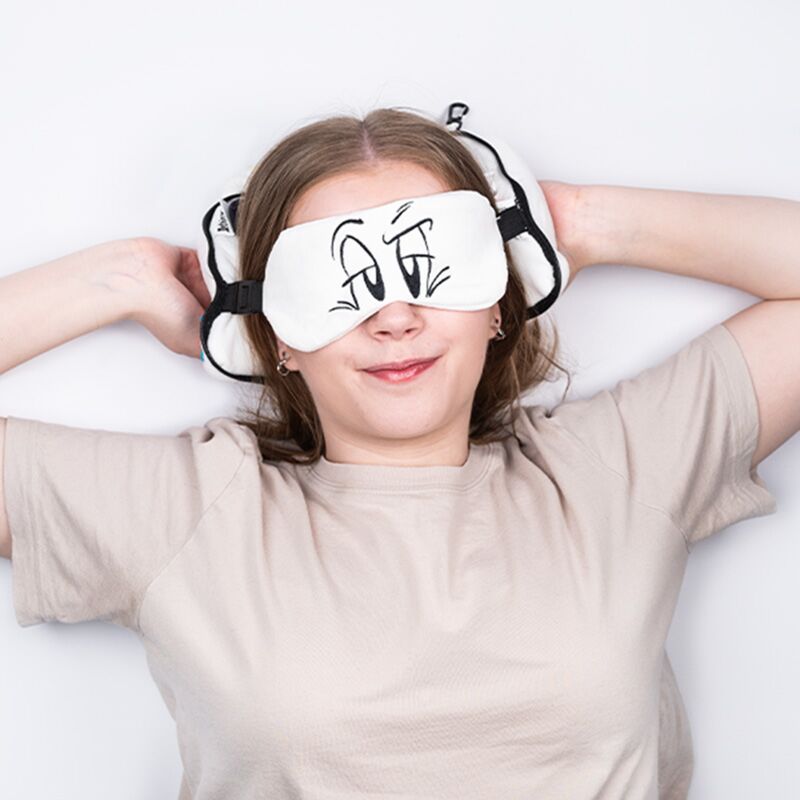 Relaxeazzz Travel Pillow & Eye Mask featuring Asterix Idefix the Dog (Dogmatix) worn by a smiling person.