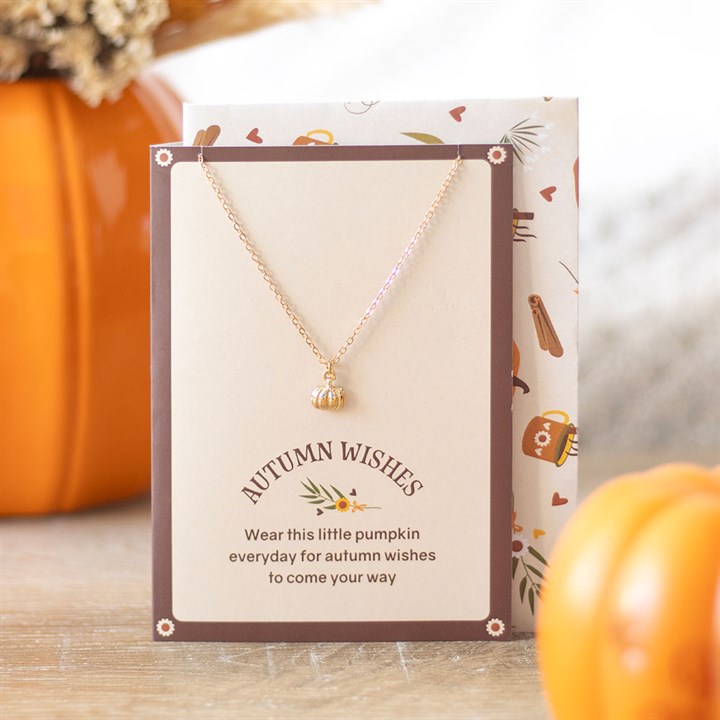 Gold-toned pumpkin necklace on a beige Autumn Wishes greeting card with a matching envelope.