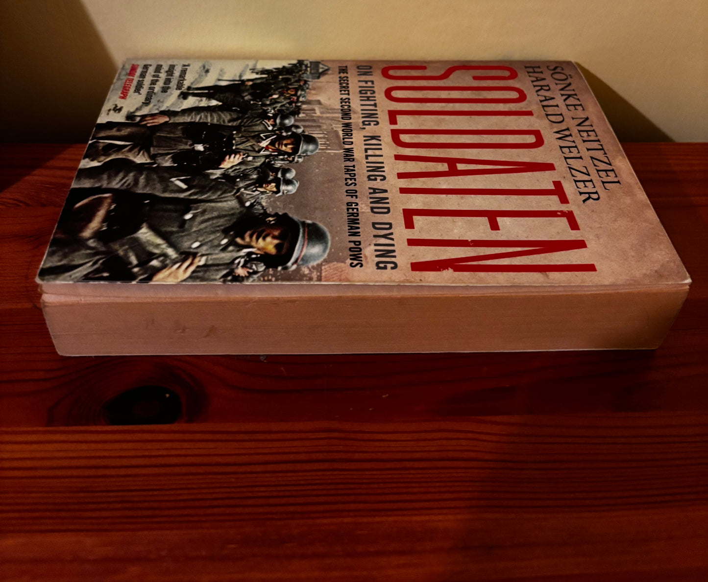 Paperback Soldaten: On Fighting, Killing and Dying - Secret Second World War Tapes of German POWs, on a wooden table.