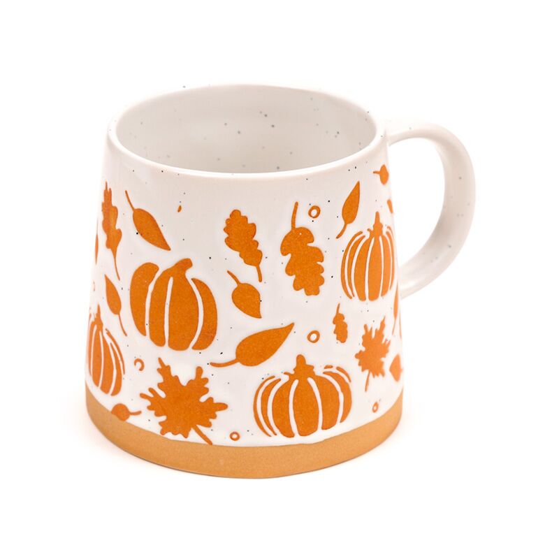 Pumpkin-themed stoneware mug with orange pumpkins and leaves on white, tan rim.