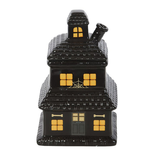 Black haunted house oil burner and wax warmer with glowing yellow windows and spider web detail