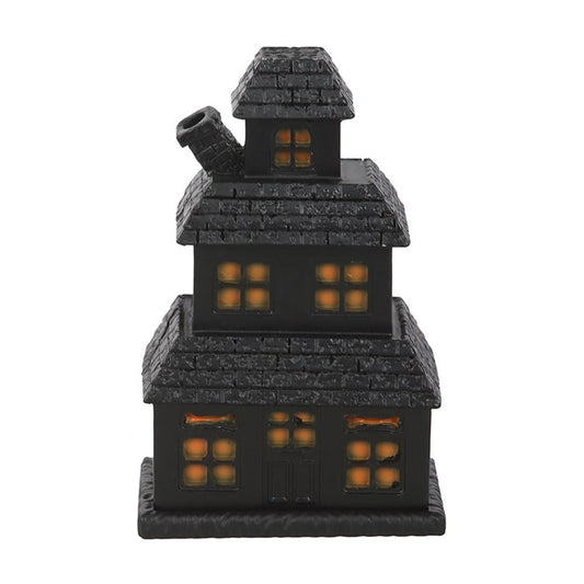 Black haunted house incense cone holder with glowing orange windows and chimney smoke.