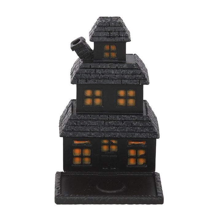 Black resin haunted house incense cone holder with stacked tiers and glowing orange windows