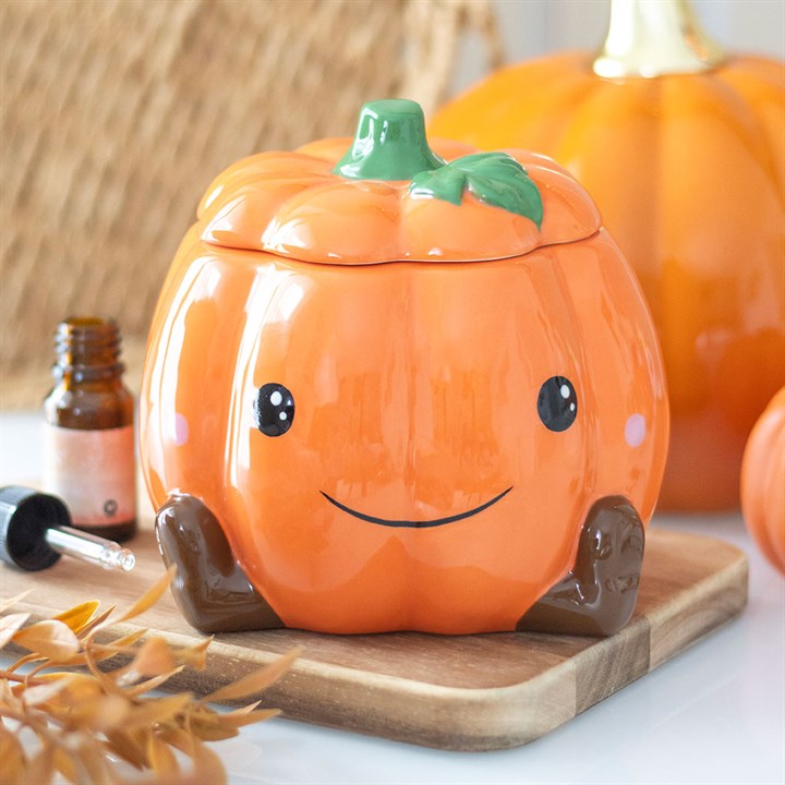 Cute smiling ceramic pumpkin oil burner and wax warmer with removable lid and star cut-outs for cosy autumn fragrances.