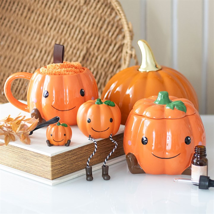 Cute ceramic pumpkin oil burner and wax warmer with a smiling face and star cut-outs, filling cosy autumn fragrance.