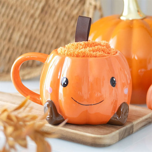 Smiling orange pumpkin mug for cosy autumn drinks.