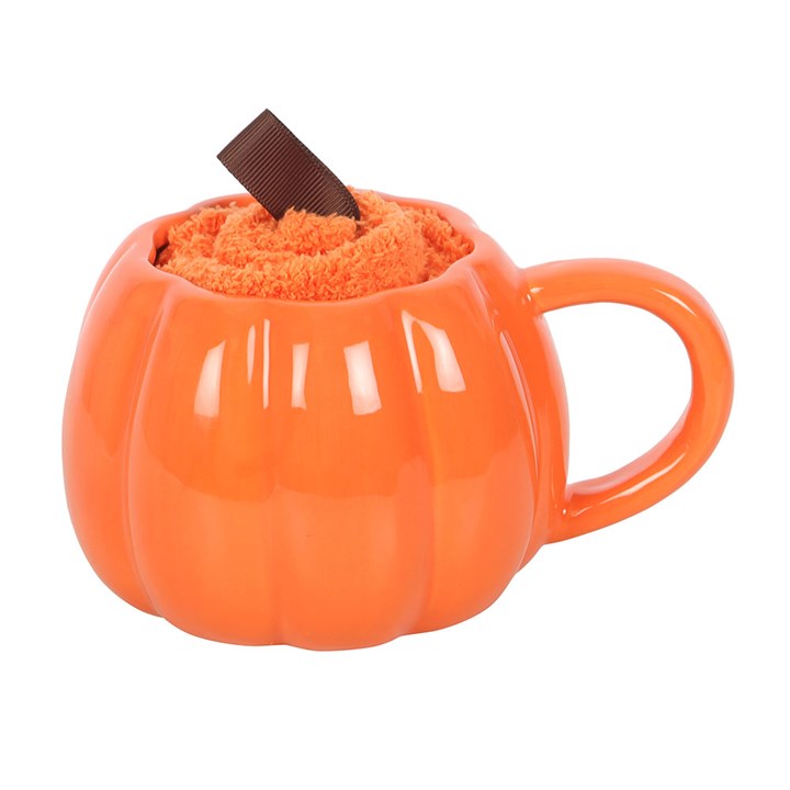 Orange pumpkin mug with fluffy orange filling and a chocolate shard, evoking cosy Halloween vibes.