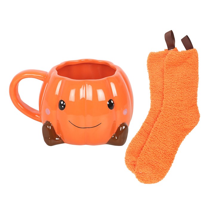 Cute smiling pumpkin mug and fluffy orange socks – cosy Halloween comfort set.