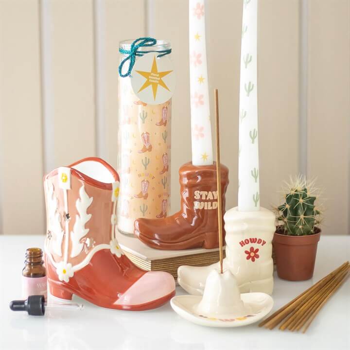 Howdy Cowboy Boot Print Floral Tube Candle showcased with decorative boot candle holders and western-themed accents.
