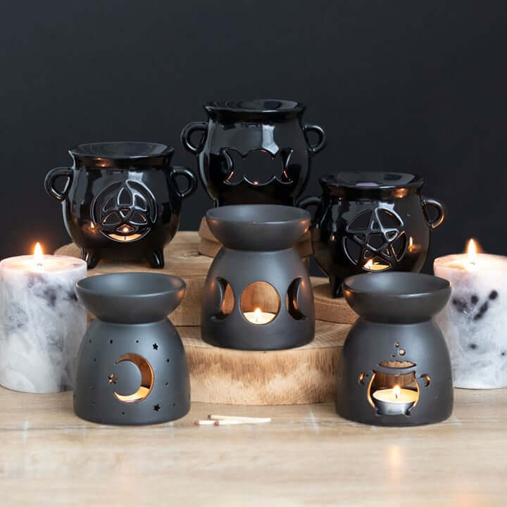 Set of black ceramic oil burners with cutout cauldron design, matte finish; for fragrance oil or wax, Halloween decor.