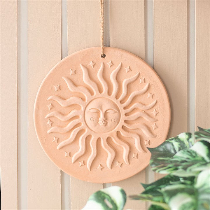 Bohemian terracotta sun plaque with embossed design, perfect for enhancing garden decor and plant displays.