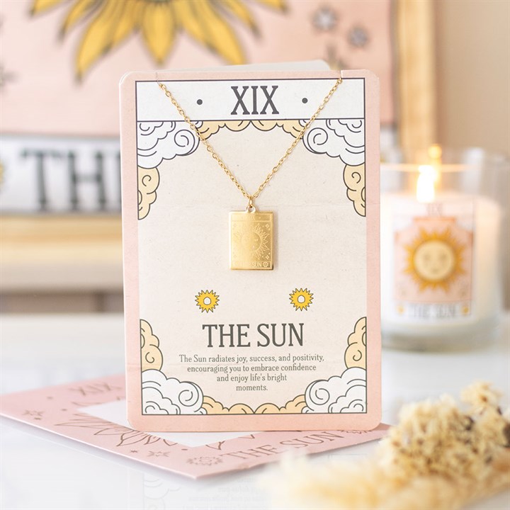 The Sun Vintage Tarot Necklace on Greeting Card with gold-toned Sun pendant on an illustrated pink card.