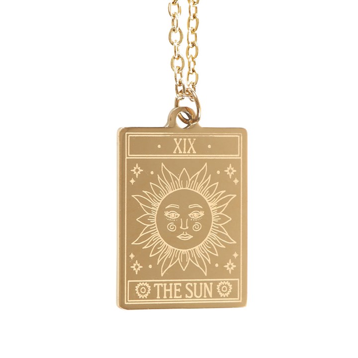Gold-toned The Sun Tarot pendant on an illustrated greeting card, sun with a face, XIX at top.