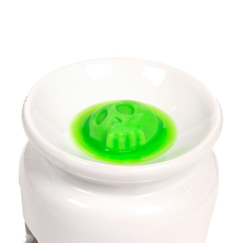 Neon green skull wax melt in a white burner dish, Toffee Apple-scented, from a 5-piece Spooky set.