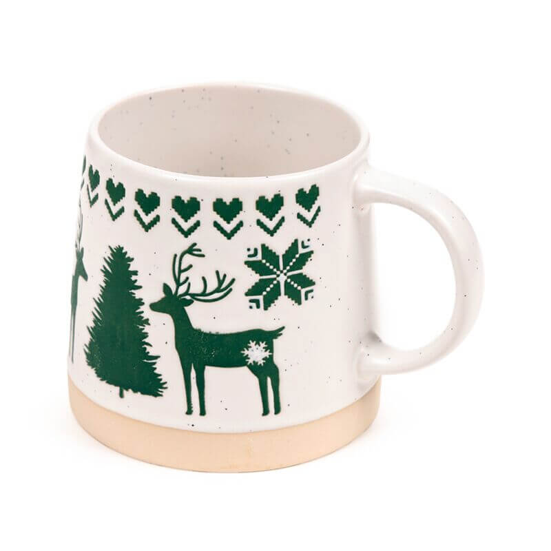 Stoneware mug in white with green reindeer, trees, snowflake and heart pattern, speckled glaze, beige foot.