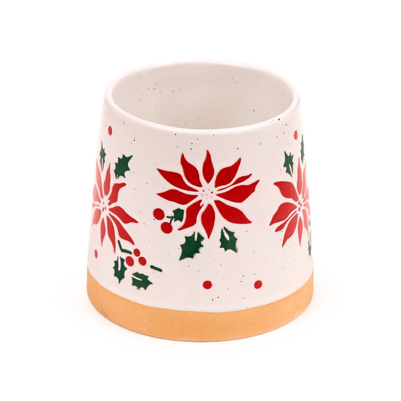 Stoneware mug with red poinsettia blossoms, green holly leaves on white speckled glaze and a gold base.