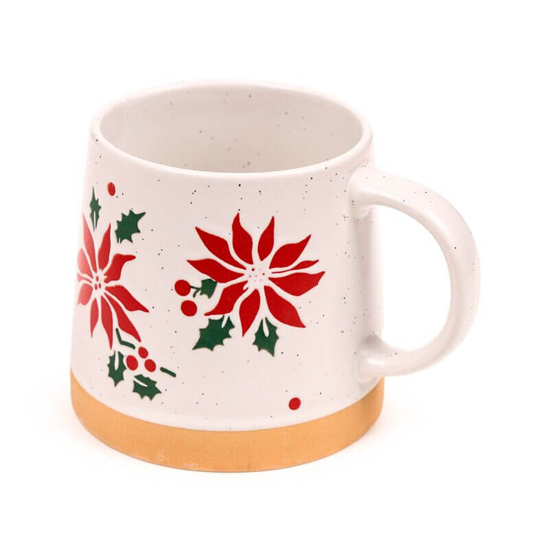Stoneware mug with red poinsettias and holly on speckled white glaze, gold base.