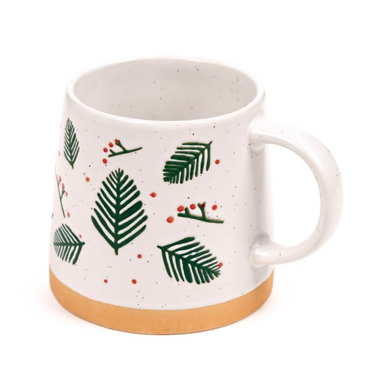 Stoneware mug featuring pine sprigs and berries, white glaze with tan base.