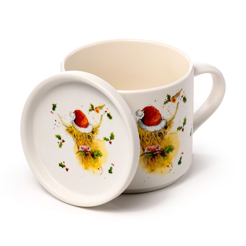 Porcelain mug with Jan Pashley Christmas Highland Coo motif and matching lid-coaster, featuring Santa hat and holly.