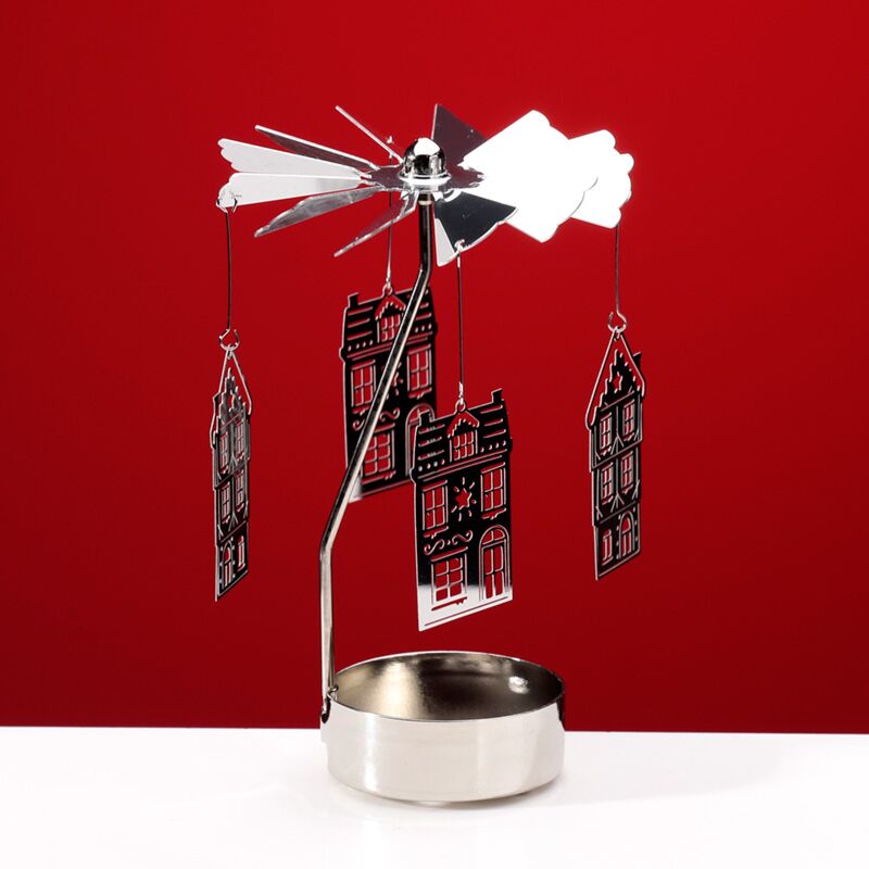Spinning tea light carousel candle holder with hanging Victorian Baker Street houses against a red backdrop.