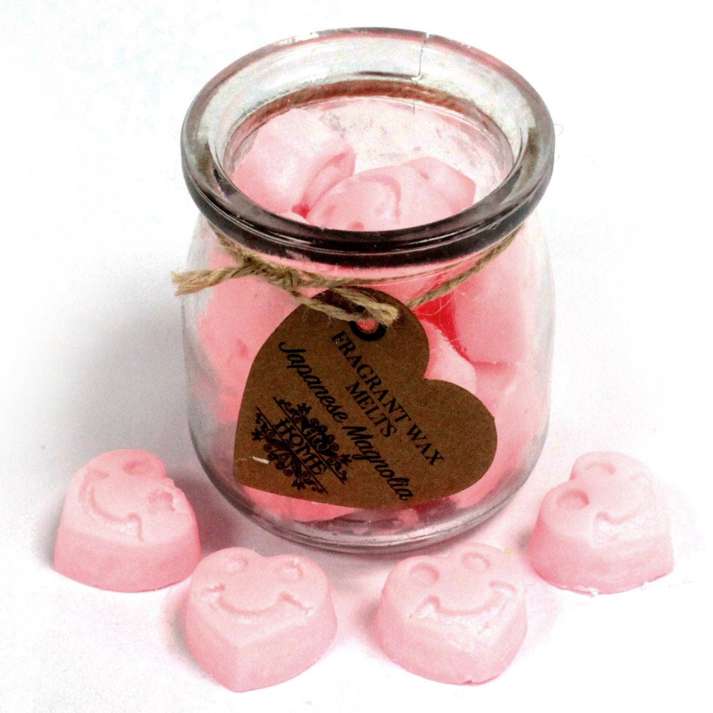 Glass jar of pink heart-shaped soy wax melts tied with twine and a brown tag, Japanese Magnolia fragrance.