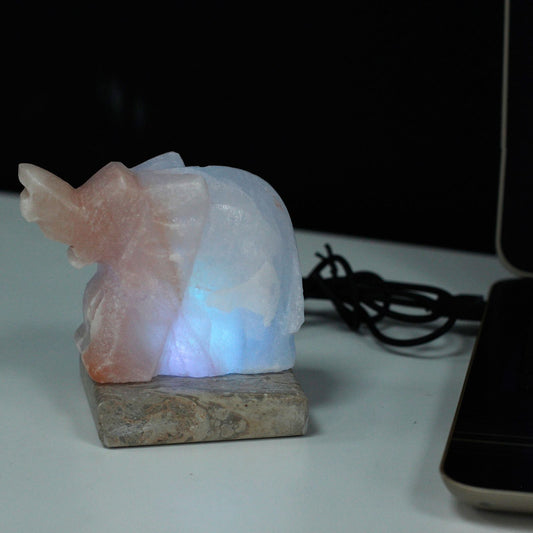 USB Elephant Shaped (Multi) Himalayan salt lamp, blue glow on stone base, USB powered.