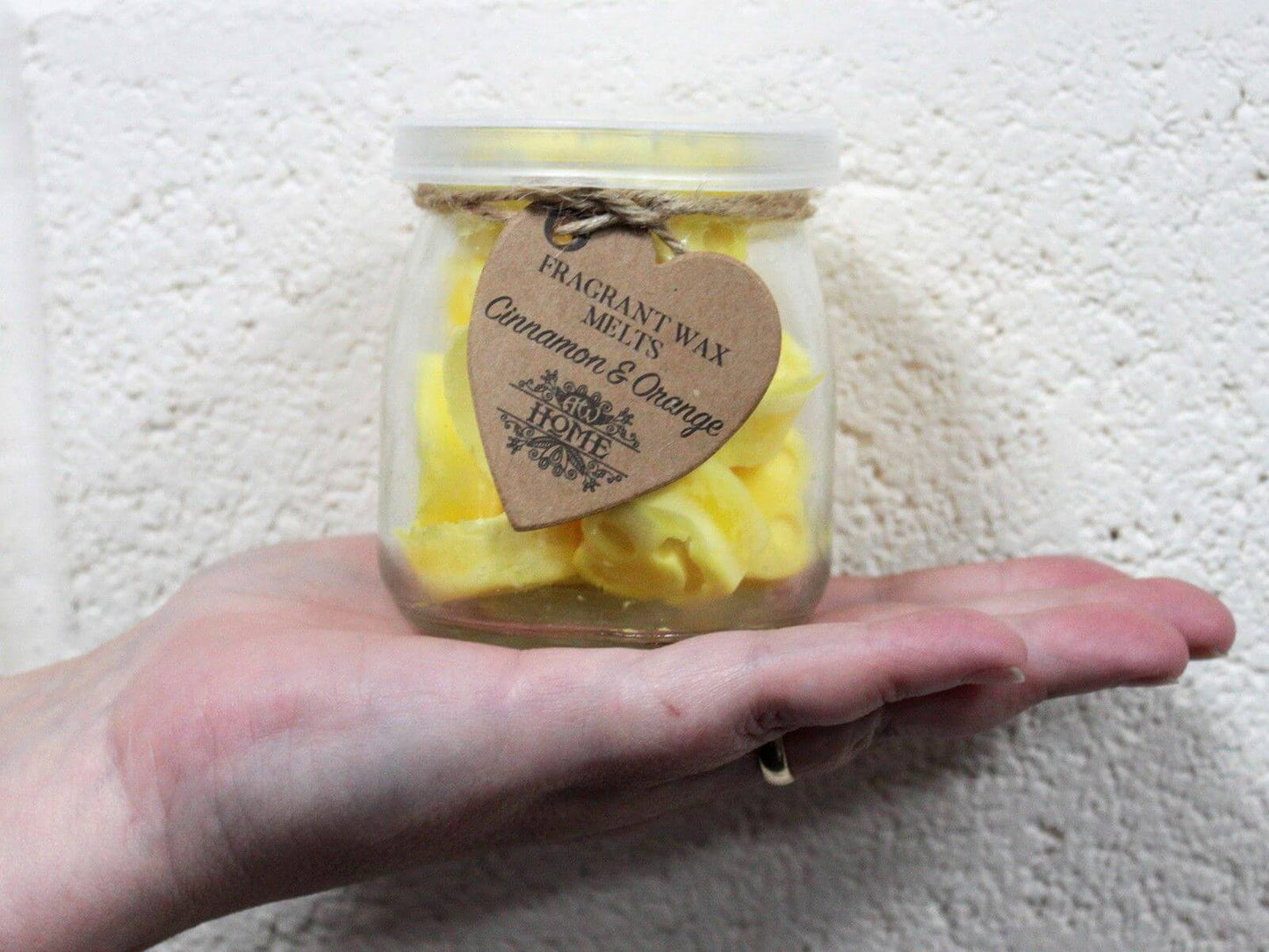 Japanese Magnolia scented soy wax melts in a 250g glass jar with yellow heart-shaped melts and a kraft heart tag.