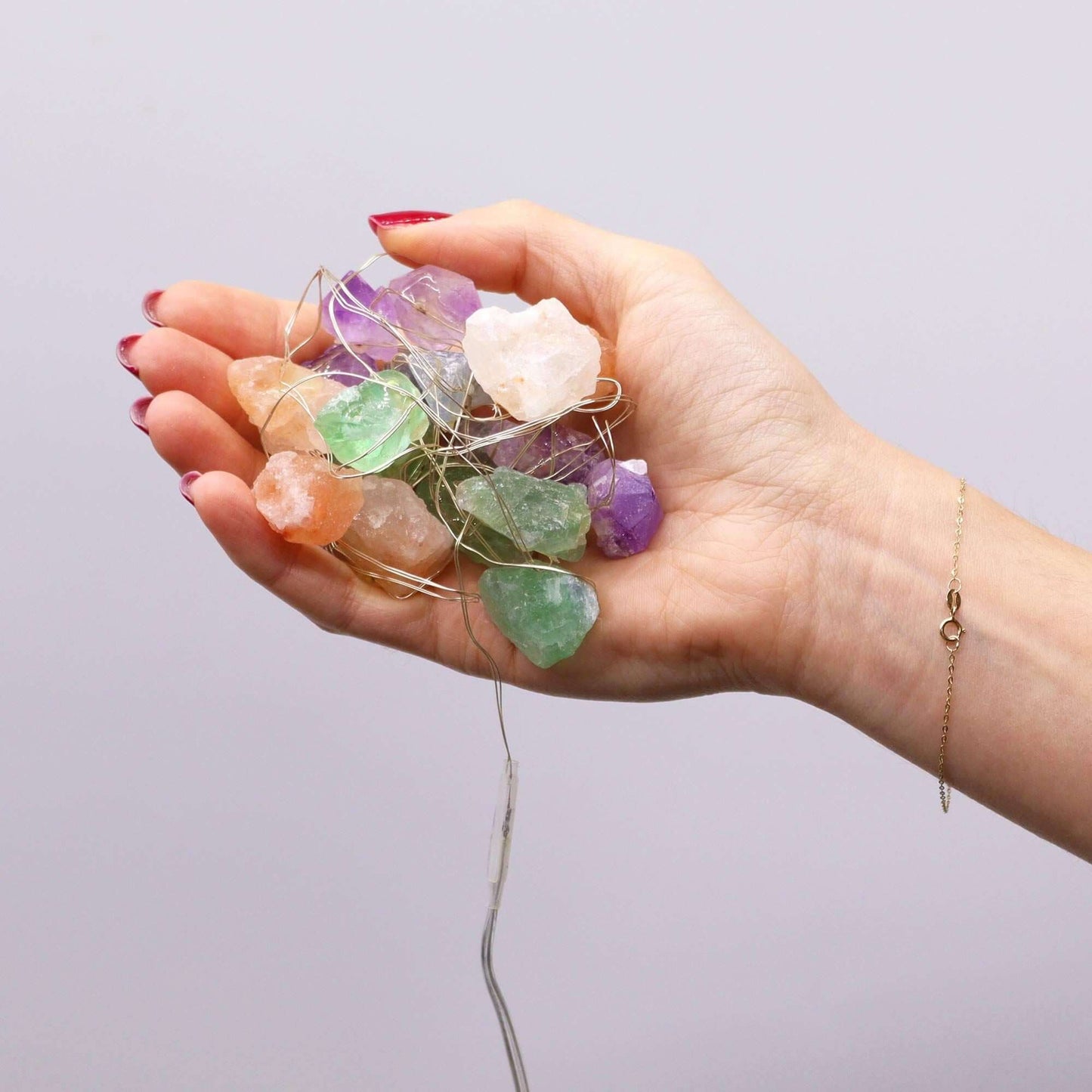 Gemstone Enchantment Lights Rainbow Mix Crystal String Lights displayed in a person's hand with colorful gemstones.