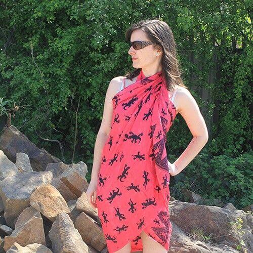 Charming Bali Gecko Sarongs - Pink, featuring a vibrant coral-pink base with playful gecko patterns and fringe trim.