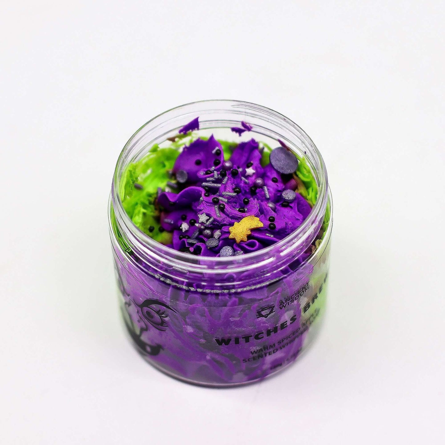 Clear jar of Witches Brew Whipped Soap 120g, purple whipped soap with green base and decorative sprinkles.