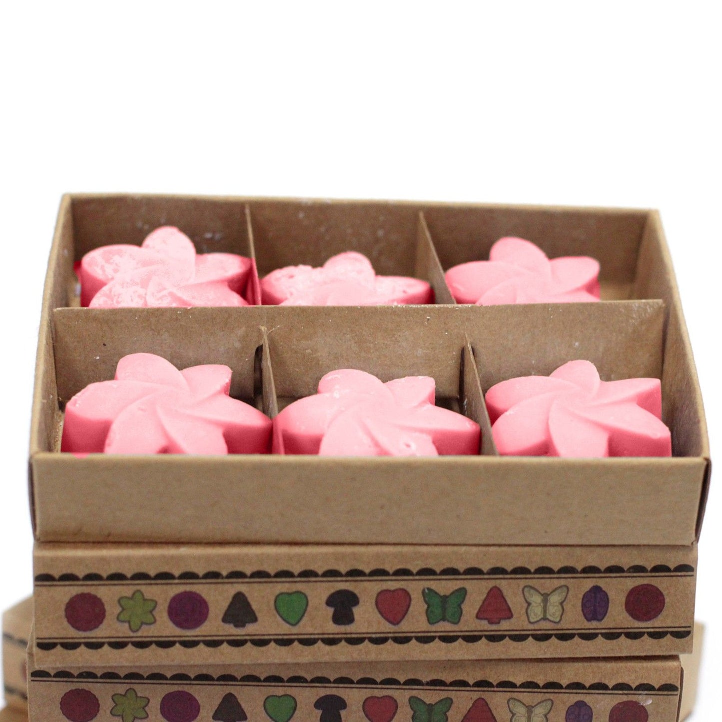 Six pink Japanese Magnolia flower wax melts in a six-compartment tray inside a brown box.