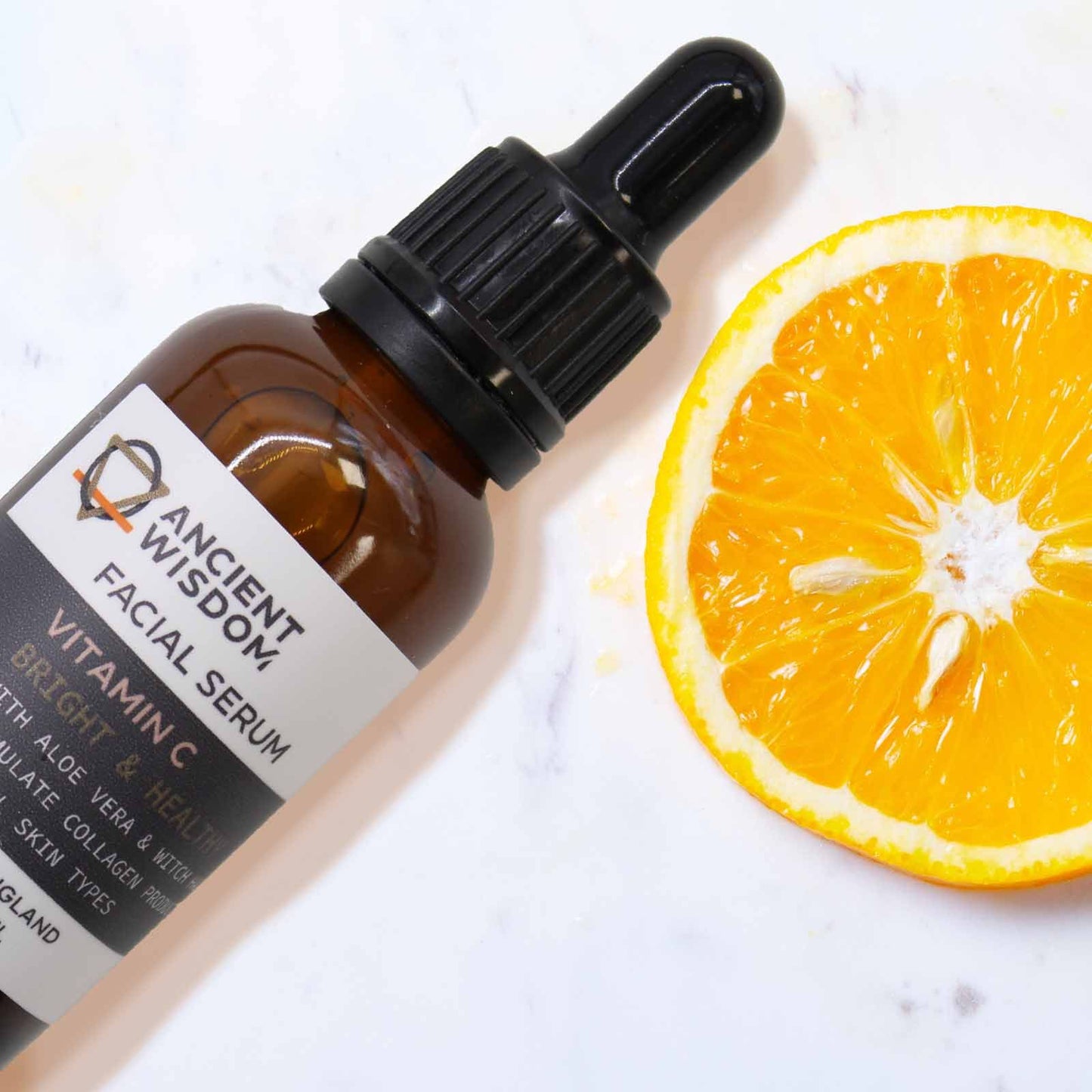 Ancient Wisdom Vitamin C Face Serum bottle with orange slice; brightening UK formula with Aloe Vera and Witch Hazel.