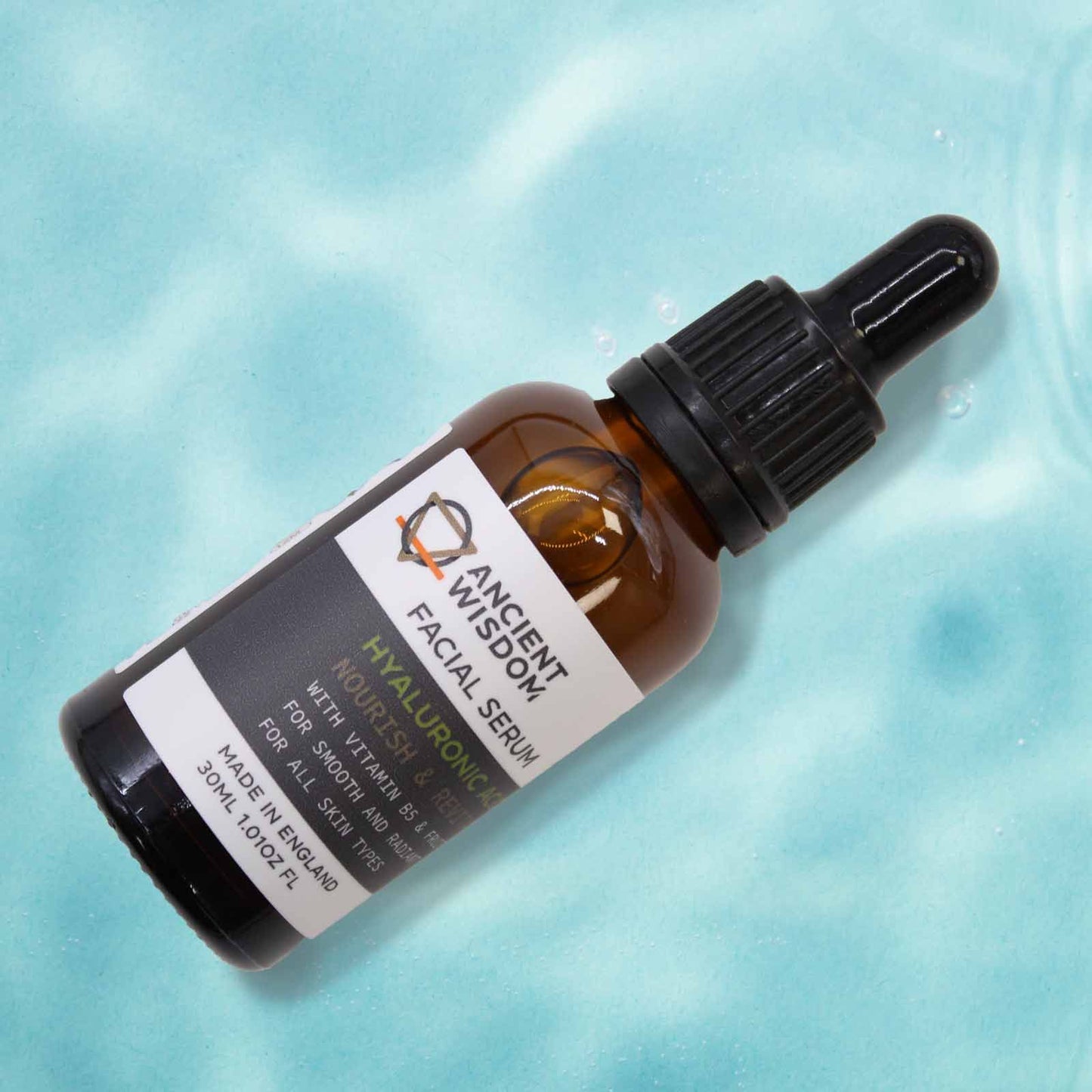 Ancient Wisdom Hyaluronic Acid Facial Serum bottle with dropper on turquoise background.