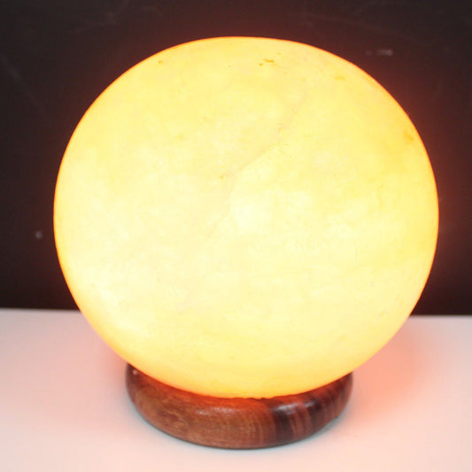 Salt Lamp Ball - Big Wooden Base illuminating Himalayan crystal glow in warm amber light.