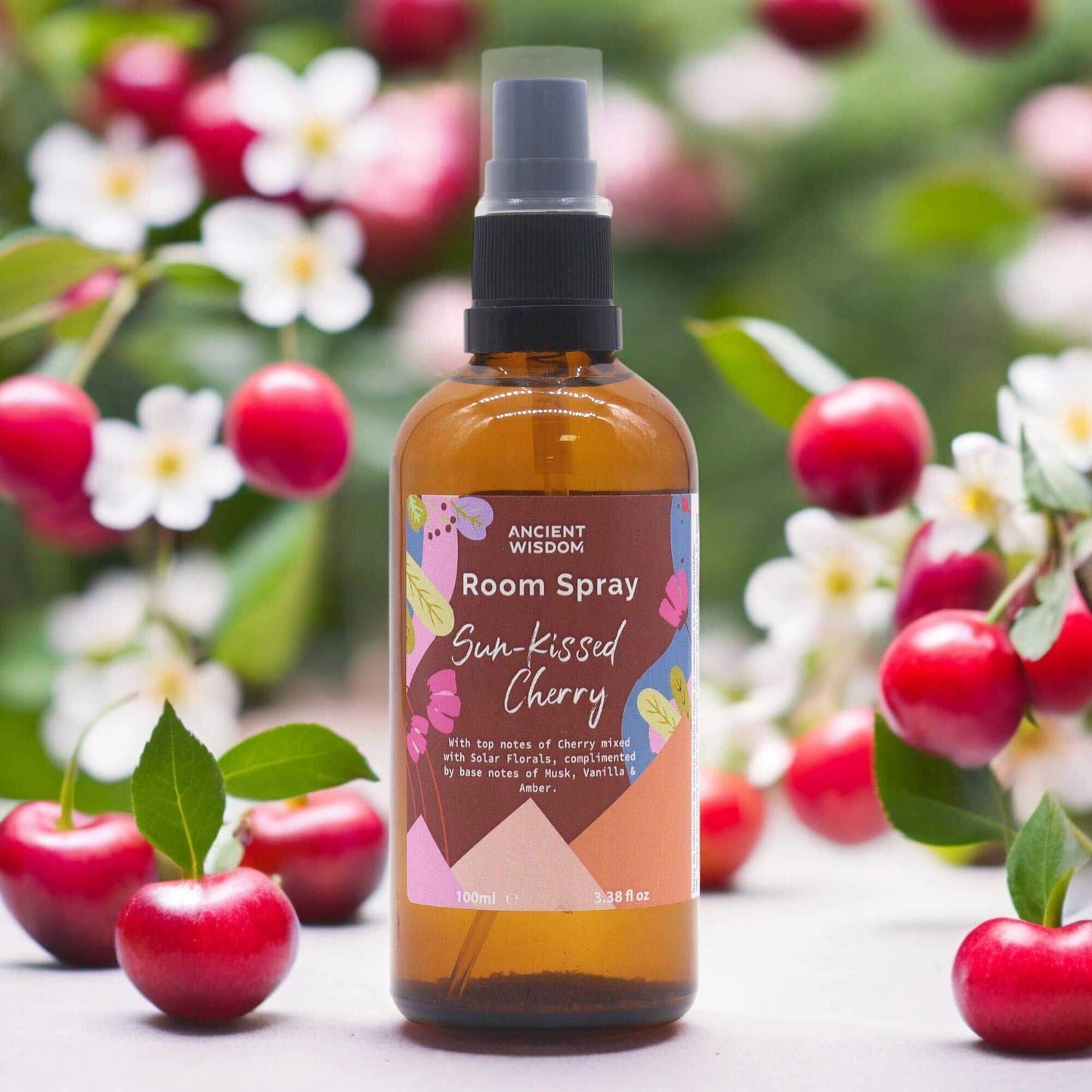 Ancient Wisdom Summer Room Spray - Sun-Kissed Cherry 100ml bottle amid cherries and blossoms, fruity floral label