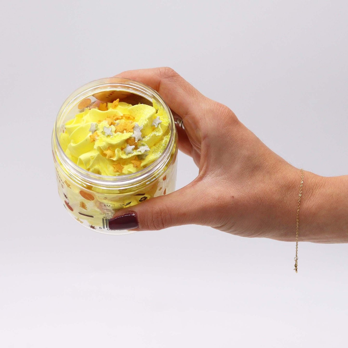 Cosy Winter Nights Whipped Soap 120g yellow whipped soap in jar with star sprinkles, held in hand.