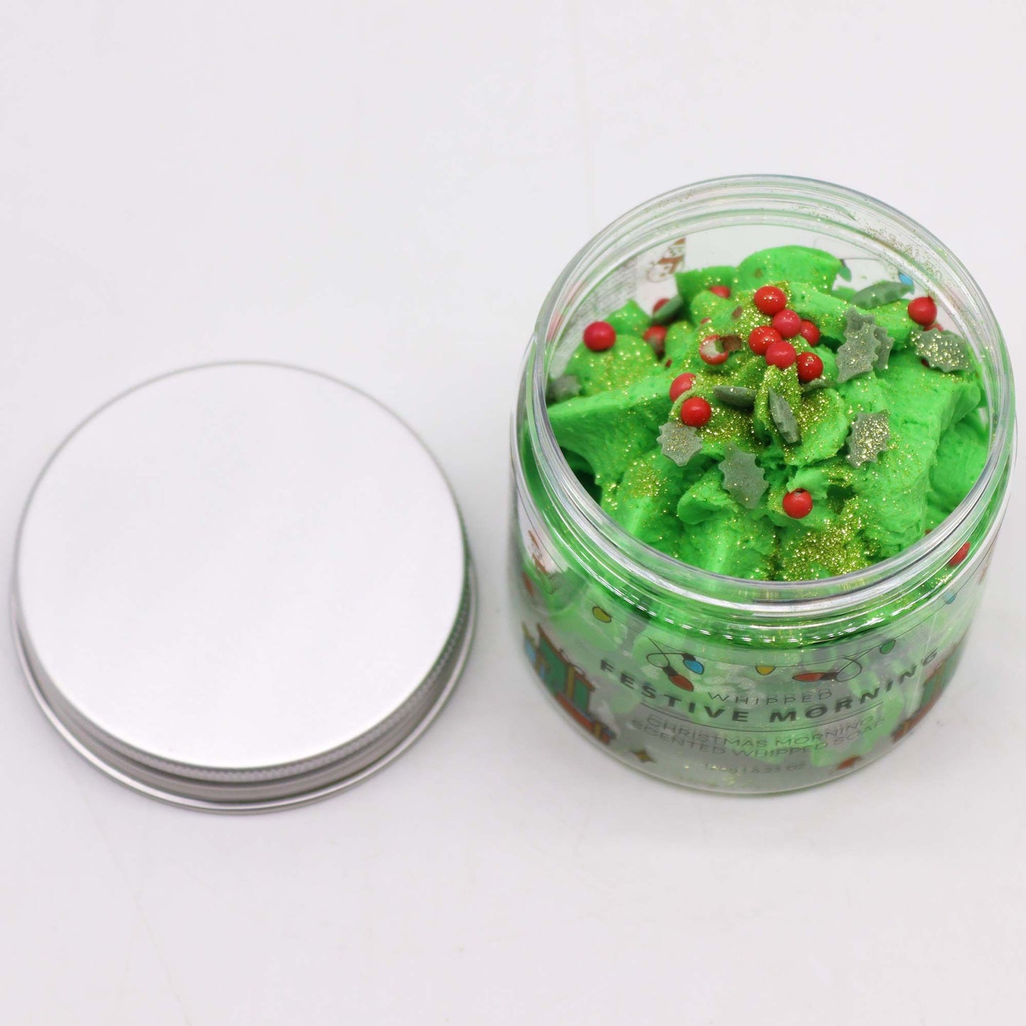 Festive Morning Whipped Soap 120g in a clear jar with bright green whipped soap, red beads and gold glitter