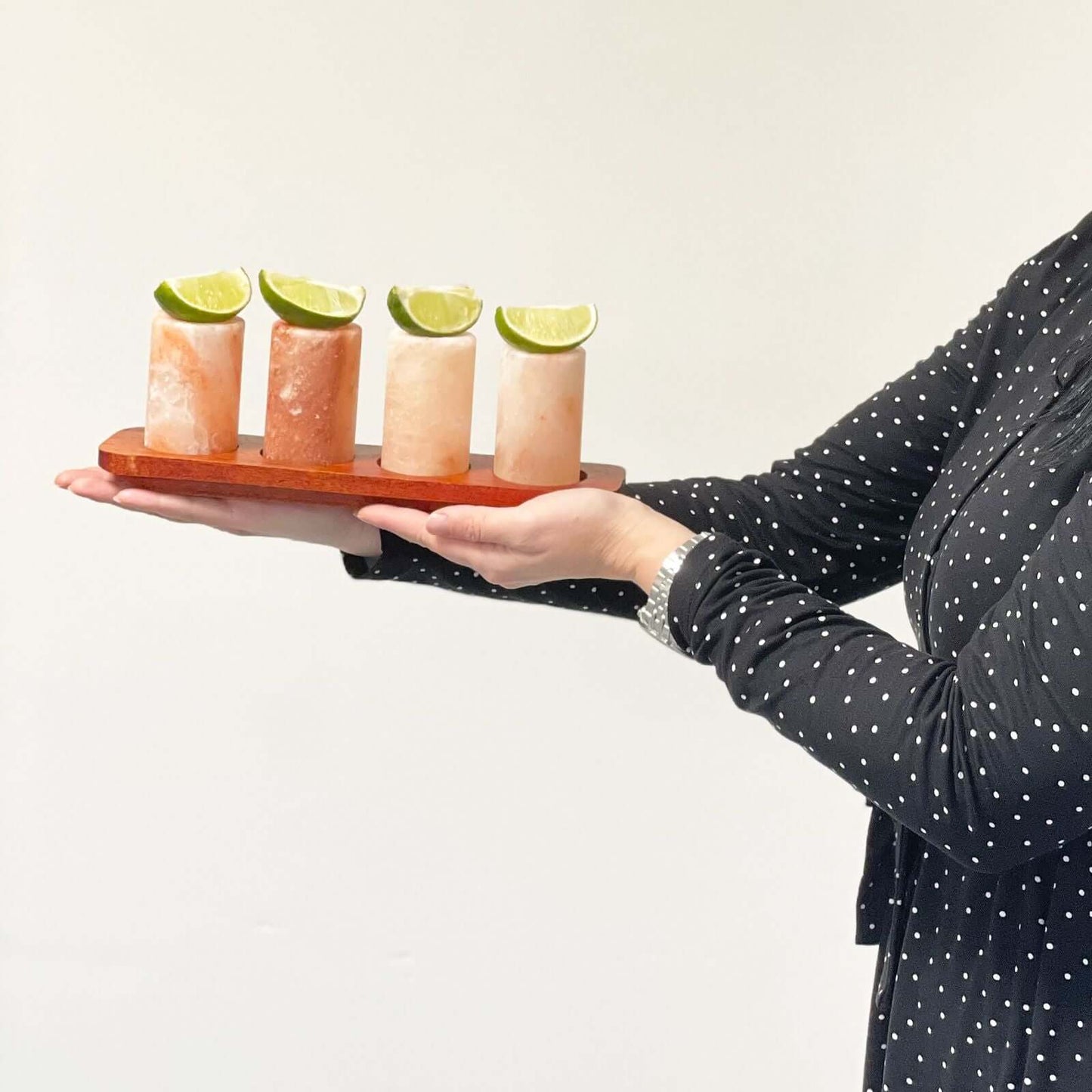 Set of 4 Himalayan Salt Shot Glasses on wooden serving stand with lime wedges