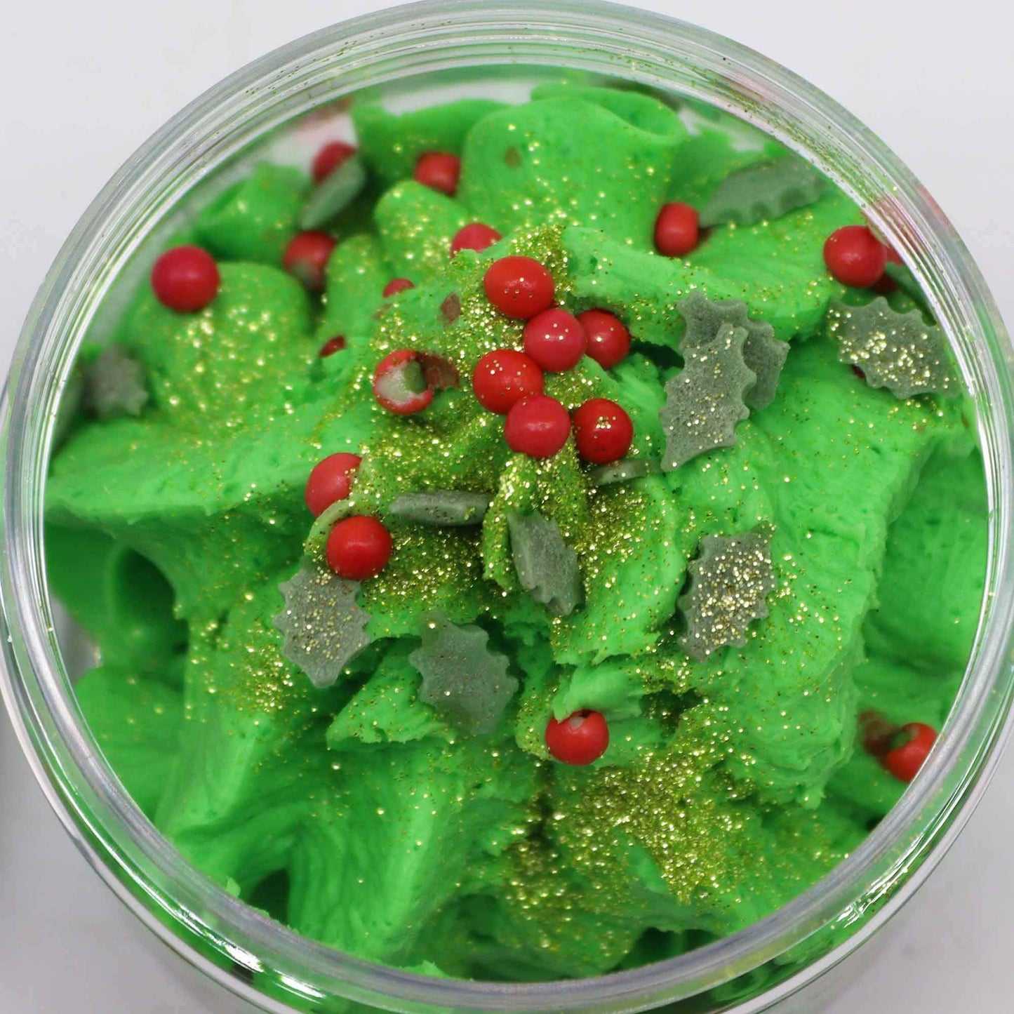 Festive Morning Whipped Soap 120g: bright green whipped soap with red berries, holly leaves and gold glitter in a jar.