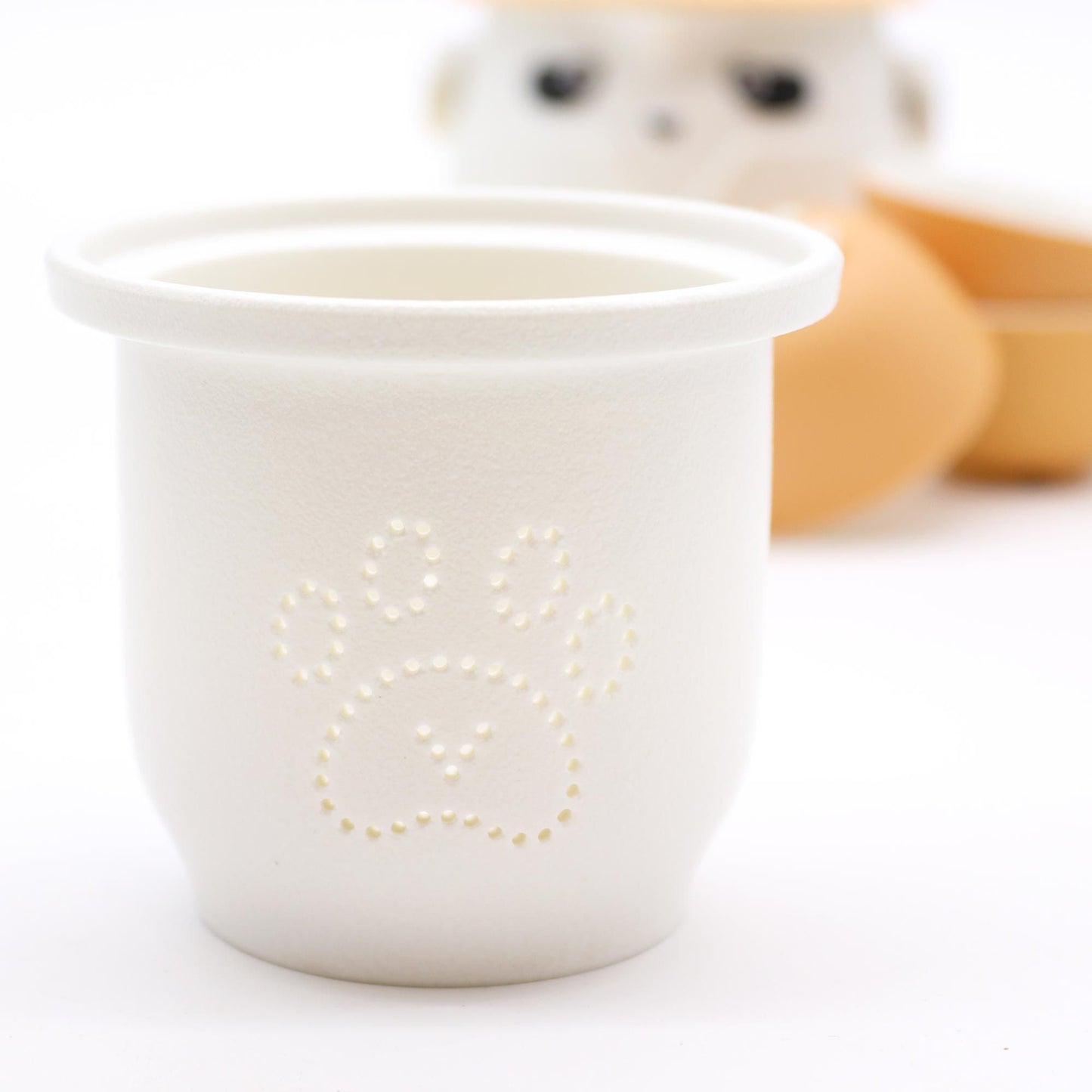Panda Teapot Set – Orange, with three cups; white cup featuring paw-print detailing in foreground.