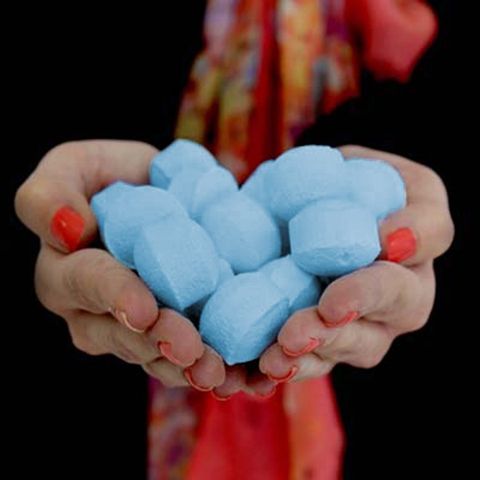 1.3Kg Box of Chill Pills (Mini Bath Bombs) - Ylang in hands, featuring soothing ylang-ylang and patchouli scents.