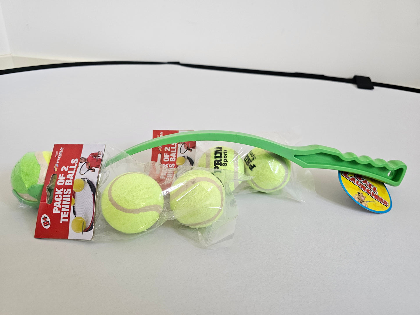Green tennis ball launcher with two packs of refill tennis balls for dogs at Fetch! Store.
