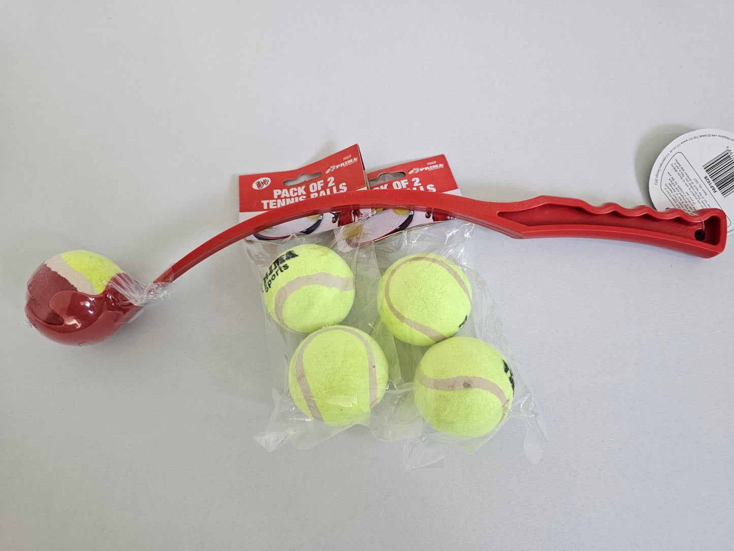 Red dog tennis ball launcher and refill pack with multiple yellow tennis balls for extended fetch sessions.