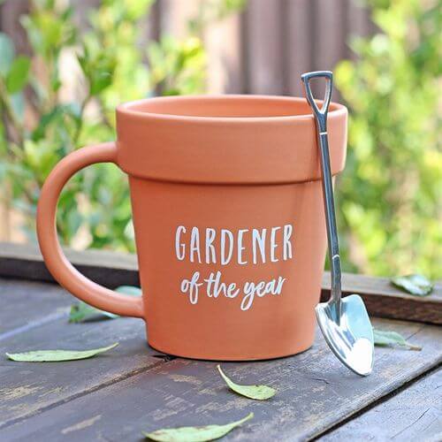 Terracotta mug resembling a plant pot, complete with a shovel spoon, perfect for gardeners of the year.
